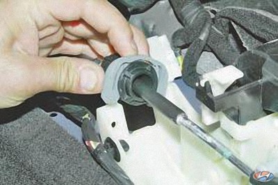 Извлеките наконечник оболочки троса управления коробкой передач из гнезда на автомобиле Hyundai Solaris