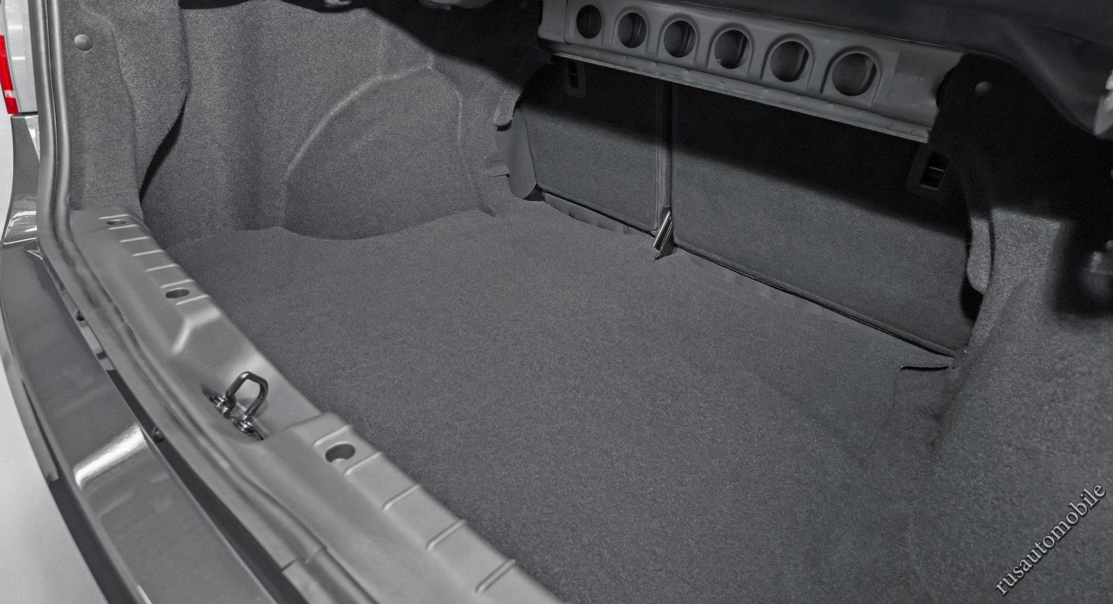 Багажник вместительный, но мешают петли крышки. Спинка заднего сиденья складывается частями, но не ровно